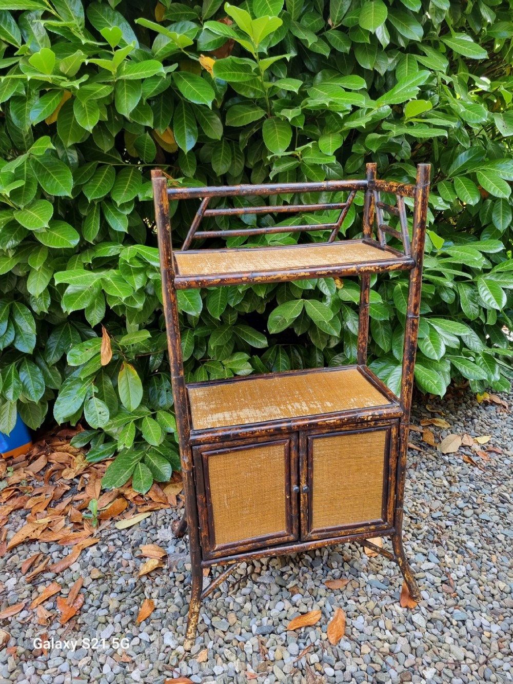 an arts and crafts british bamboo stand with cupboard